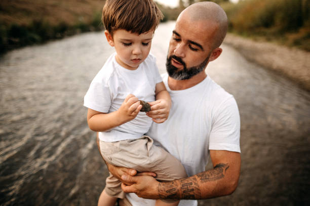 padre e figlio che esplorano il fiume - tattoo father family son foto e immagini stock