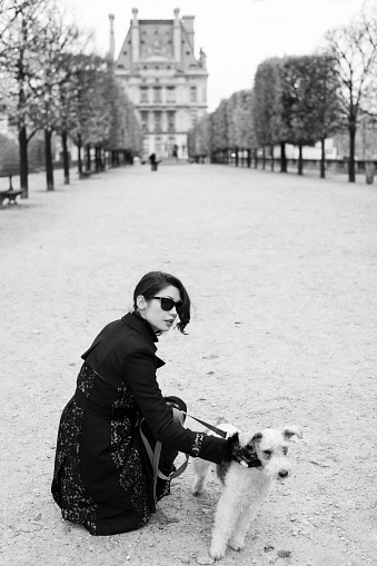 Woman with a dog in Tuileries in Paris, France.
