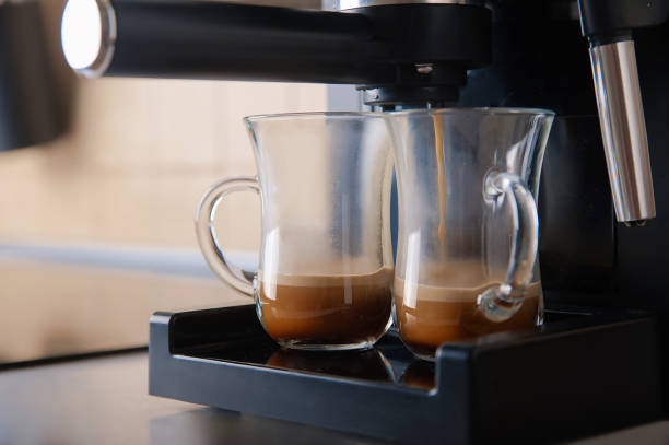 istock Two transparent cups coffee close-up front view. Home coffee maker and process of making coffee drink. 1338946581