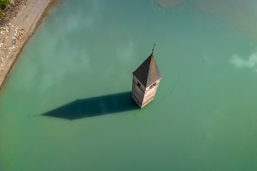 Submerged bell Tower of Curon at Graun im Vinschgau on Lake Reschen aerial view, South Tyrol region Italy