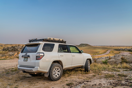 Carr, CO, USA - September 6, 2021: Toyota 4Runner SUV (2016 Trail edition) at dusk on a prairie road in northern Colorado, late summer scenery with smoke and haze from distant wildfires.