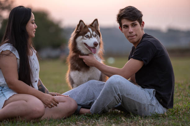 istock young couple with a dog at the park 1338954642