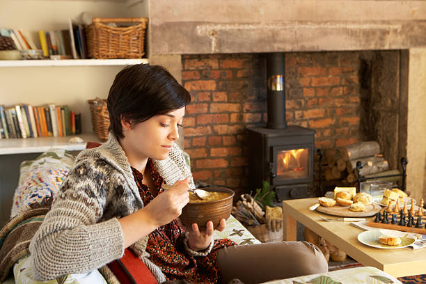 Young woman eating by fire