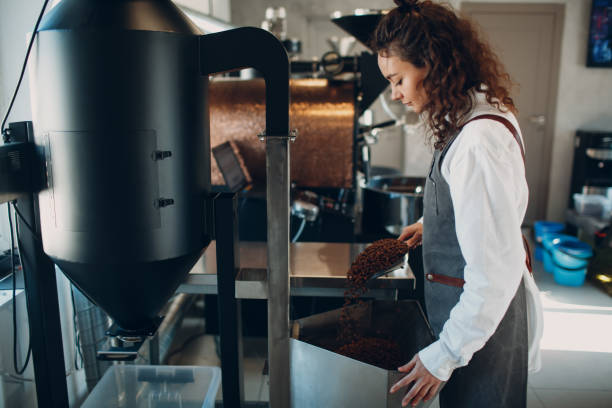 istock Woman worker at Coffee destoner machine at coffee roasting process 1338957285
