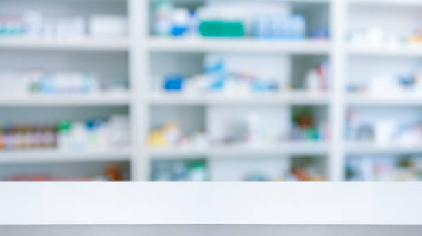 istock Empty white counter with pharmacy drugstore shelves blurred background 1338957575