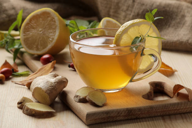istock Autumn composition with hot tea with ginger and lemon on a natural wooden table. 1338957797