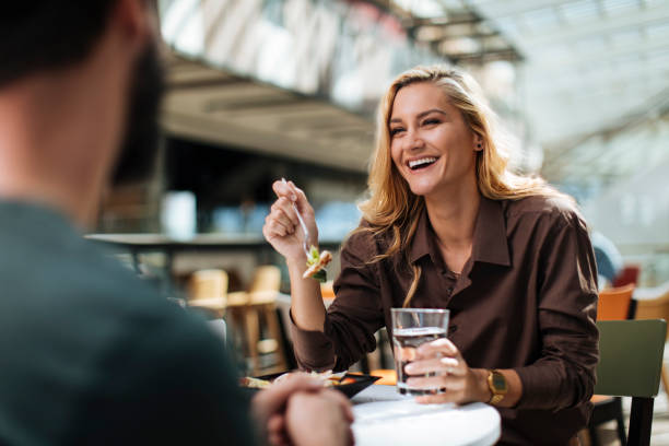 Beautiful woman having fun during meal Beautiful woman having lunch and having fun with friend food court photos stock pictures, royalty-free photos & images