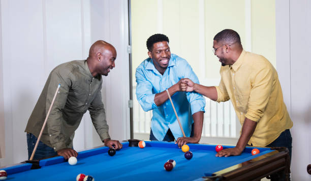 istock Three African-American men shooting pool, fist bump 1338970335