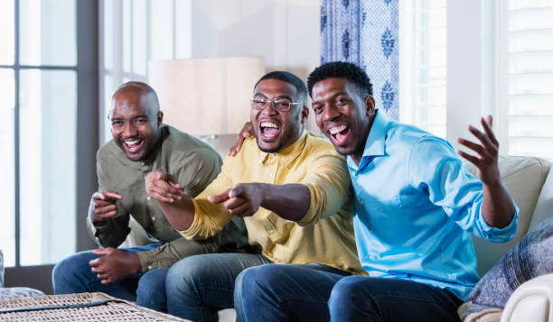 istock Three African-American men on couch laughing, pointing 1338970347