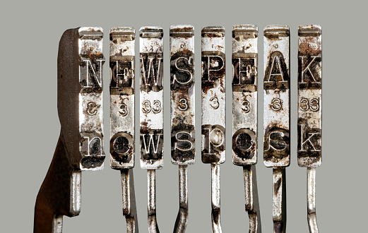 vintage old typewriter hammers  with the word  newspeak