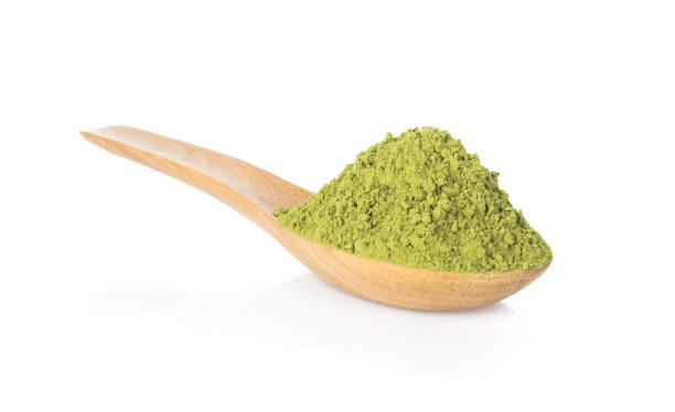 Powder green tea on wooden spoon isolated on white background