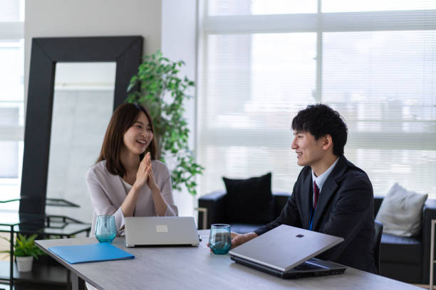 istock Man and woman talking happily in an office 1338975883