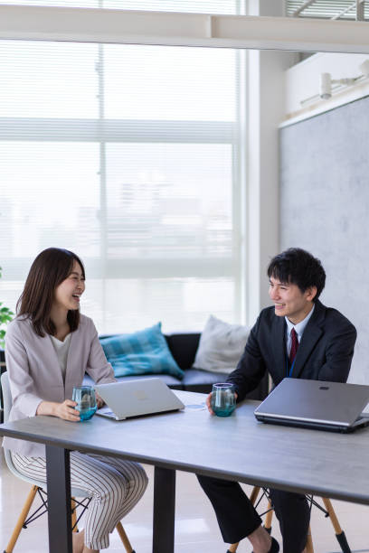 istock Man and woman talking happily in an office 1338975887