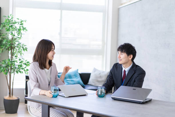 istock Man and woman talking happily in an office 1338975890