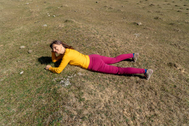 기쁨으로 태양을 바라보는 초원에 누워 있는 한 여성 - lying on front joy enjoyment happiness 뉴스 사진 이미지