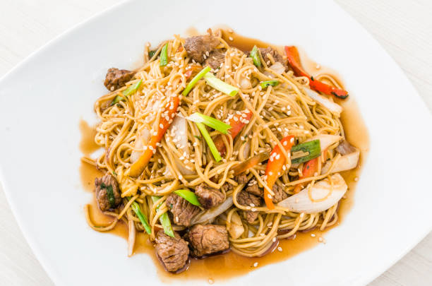 istock Peruvian style beef spaghetti pasta with basil leaves called tallarin saltado de carne. 1338978965