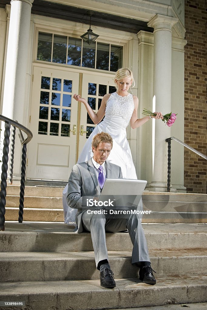 Working Groom Stock photo of an upset bride and her workaholic groom in front of the church on their wedding day. 20-29 Years Stock Photo