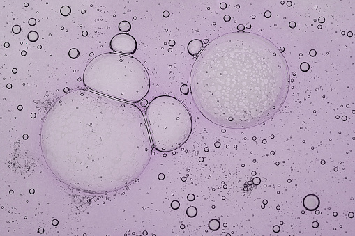 Liquid serum, gel bubbles in light purple color. Macro