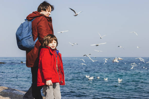 istock Dad with a small child walking on a winter beach 1338988086