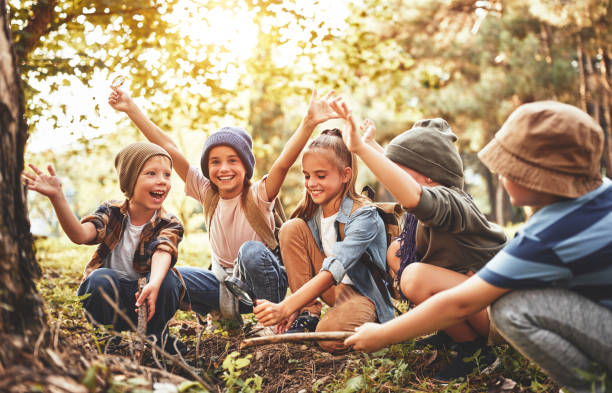 istock Happy school kids scouts learning how to create fire with magnif 1338989916