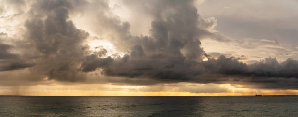 Dramatic sky with massive rain clouds over the Indian Ocean on the scenic sunset in Hikkaduwa, Sri Lanka, in the winter season. Stitched high-resolution panorama. Dramatic sky with massive rain clouds on the scenic sunset in Hikkaduwa, Sri Lanka, in the winter season. tropical storm photos stock pictures, royalty-free photos & images