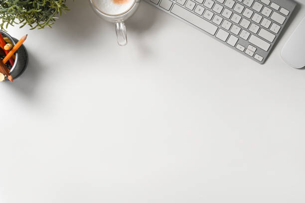 istock Top view white office desk with keyboard, coffee cup and pencil holder. 1338991209