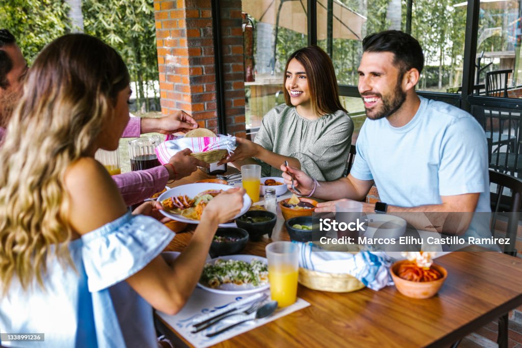 Group of latin friends eating mexican food in the restaurant terrace in Mexico Latin America Restaurant Stock Photo