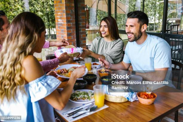 Group Of Latin Friends Eating Mexican Food In The Restaurant Terrace In Mexico Latin America Stock Photo - Download Image Now