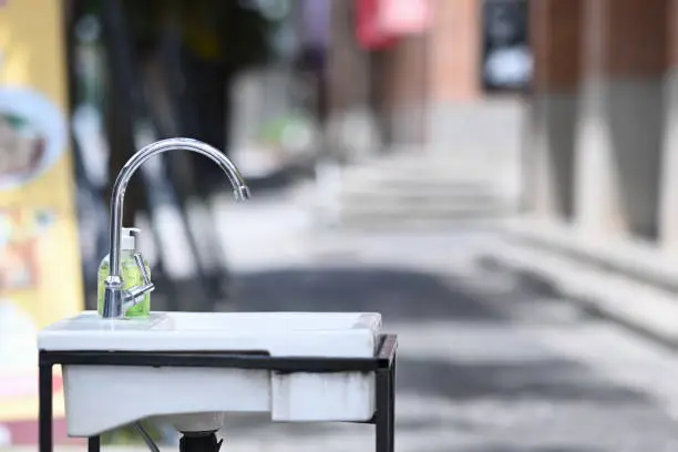 Photo of Faucets and sinks for washing hands at outdoor in the city.