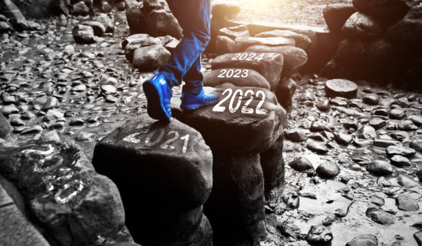 jovem cruzando degraus com o número 2020 a 2022 e 2024 - stepping stone stone stepping footpath - fotografias e filmes do acervo