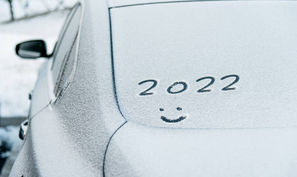 istock New year 2022 and smiling face written on the rear windshield with snow 1338994267
