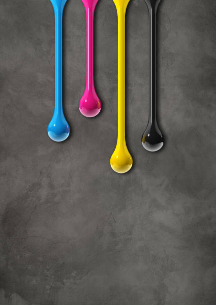 istock cmyk ink drops on dark concrete background 1338994398