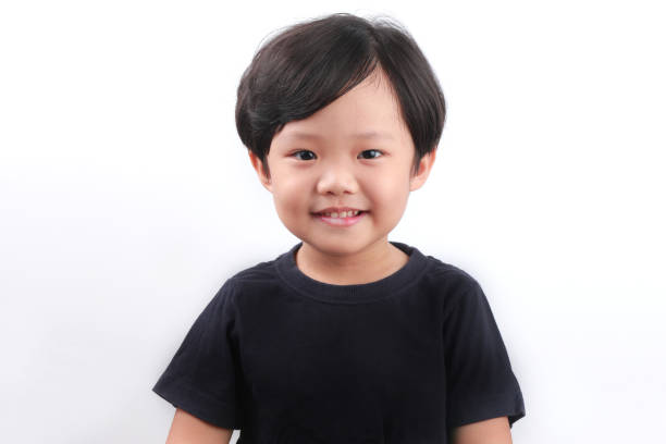 istock Little Asian Boy Smiling, Standing Against White Wall 1338995445