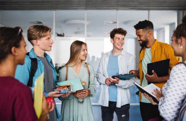istock Group of university students standing in corridor indoors, talking. 1338995752