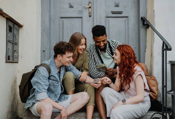 istock Group of young people outdoors on trip in town, using map on smartphone. 1338996592