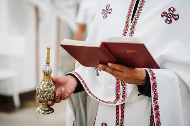司祭は教会で聖書を持っています。聖なる聖餐の行事。クローズアップ。 - greek orthodox ストックフォトと画像