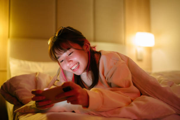 donna felice che tiene lo smartphone a casa - smart phone china mobile phone asia foto e immagini stock