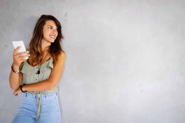 Portrait of smiling happy beautiful woman using smartphone. Technology, device people concept