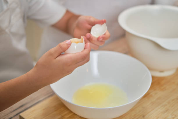 istock Boy hands separating the egg white from the yolk for the pie 1339002940