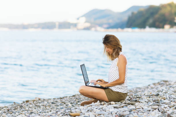 istock A woman combines remote work at a laptop and a vacation on the seashore 1339005657