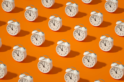 Reloj despertador sobre fondo de color naranja photo