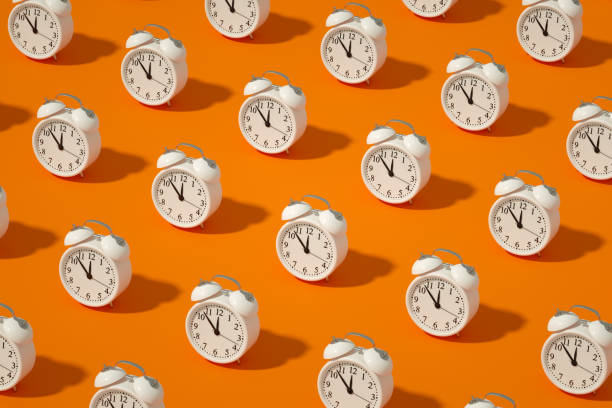 reloj despertador sobre fondo de color naranja - conceptos ilustraciones fotografías e imágenes de stock