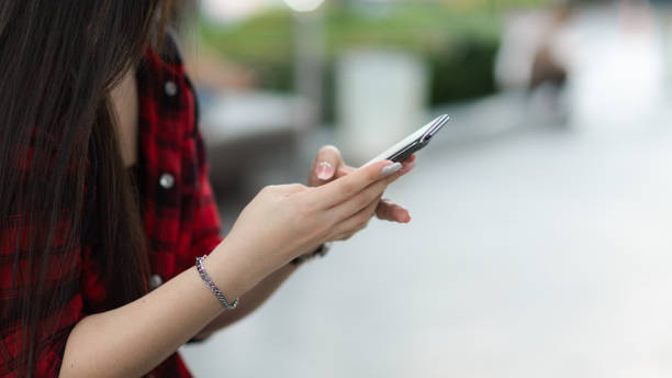 istock Cropped image of Charming asian woman using mobile phone 1339006876