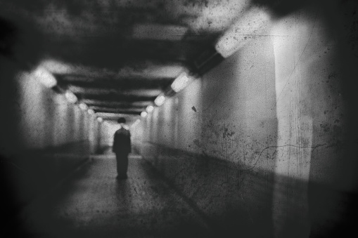 Silhouette of a man standing in a tunnel