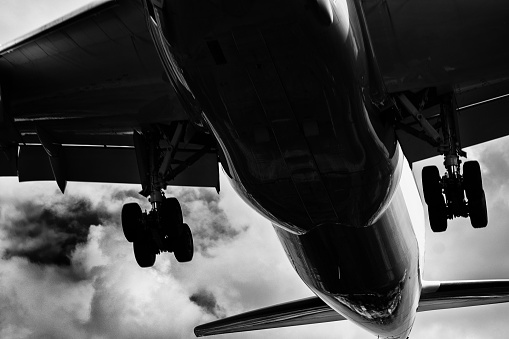 The image shows the nose of a Boeing B-17F WWII bomber.  The aircraft is parked on the ramp with a backdrop of a brooding, low overcast.  In black and white tones the photo presents a vintage, gritty quality like it was from the period.  The photo was taken at the Grant County International Airport in Moses Lake, WA.