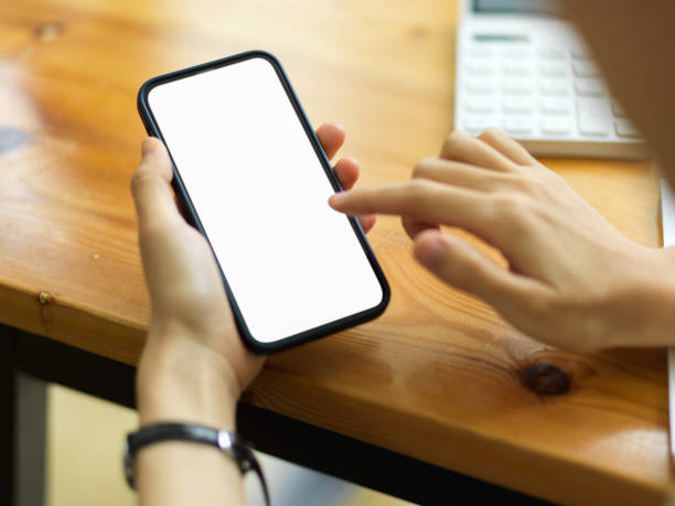 istock Mobile phone white screen mockup, holding by young female 1339011756