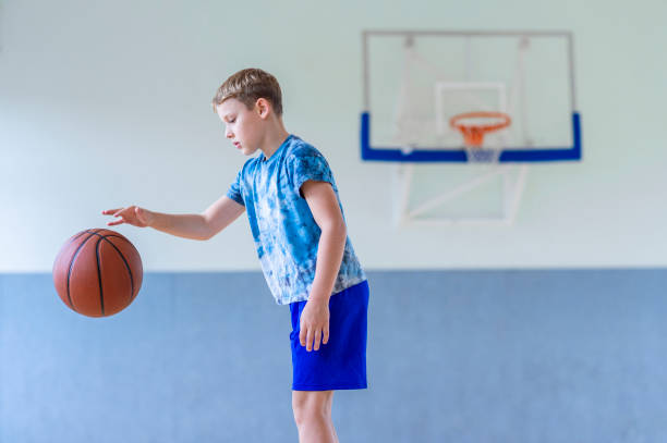 istock School kid playing basketball in a physical education lesson. Horizontal education poster, greeting cards, headers, website. Safe back to school during pandemic concept 1339012855