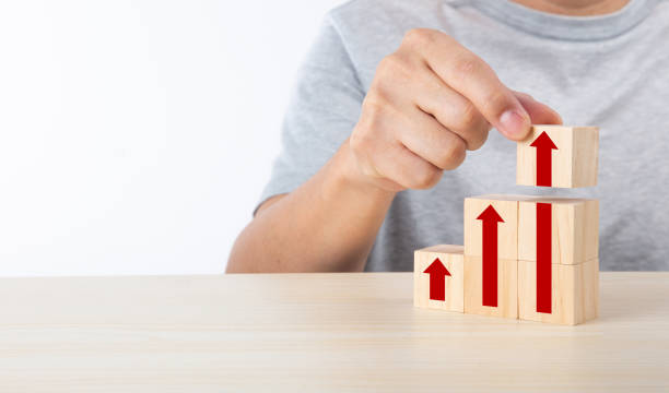istock Hand arranging wood block stacking as step stair with arrow up. Ladder career path concept for business growth success process 1339014056