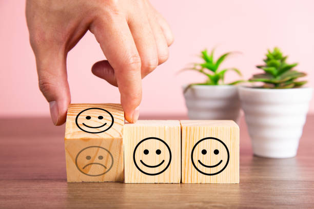 istock Customer service evaluation and satisfaction survey concepts. The client's hand turned the happy face smile on wooden blocks, copy space 1339014327