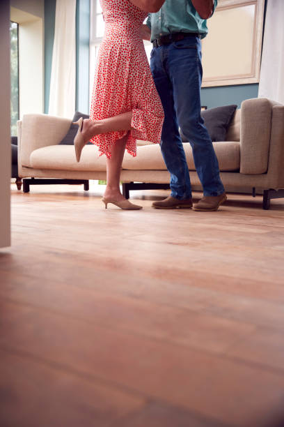 close up on legs as romantic senior retired couple dancing in lounge at home together - date night imagens e fotografias de stock